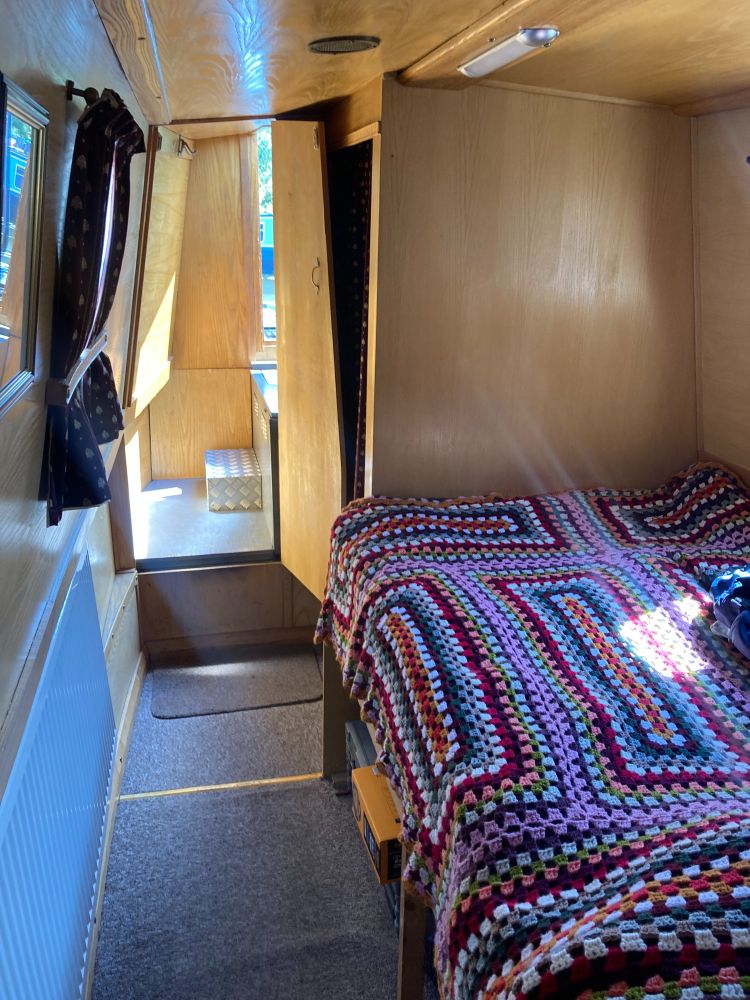 narrowboat bedroom with small double bed and zany crochet blanket