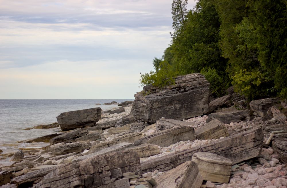 large dolostone and limestone boulders scattered on the shore of the georgian bay which once made up the upper ledge of the escarpment, the supporting shales and sandstones having been weathered away over time