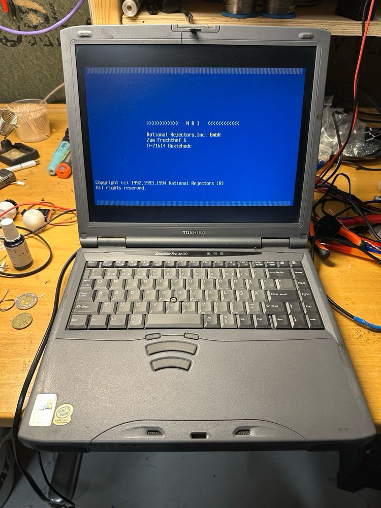 A Toshiba laptop, running DOS and a coin rejector configurator software. 