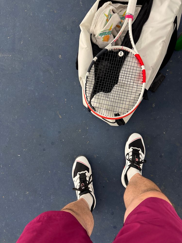 My feet (in K-Swiss tennis shoes) and my Babolat tennis racquet. 