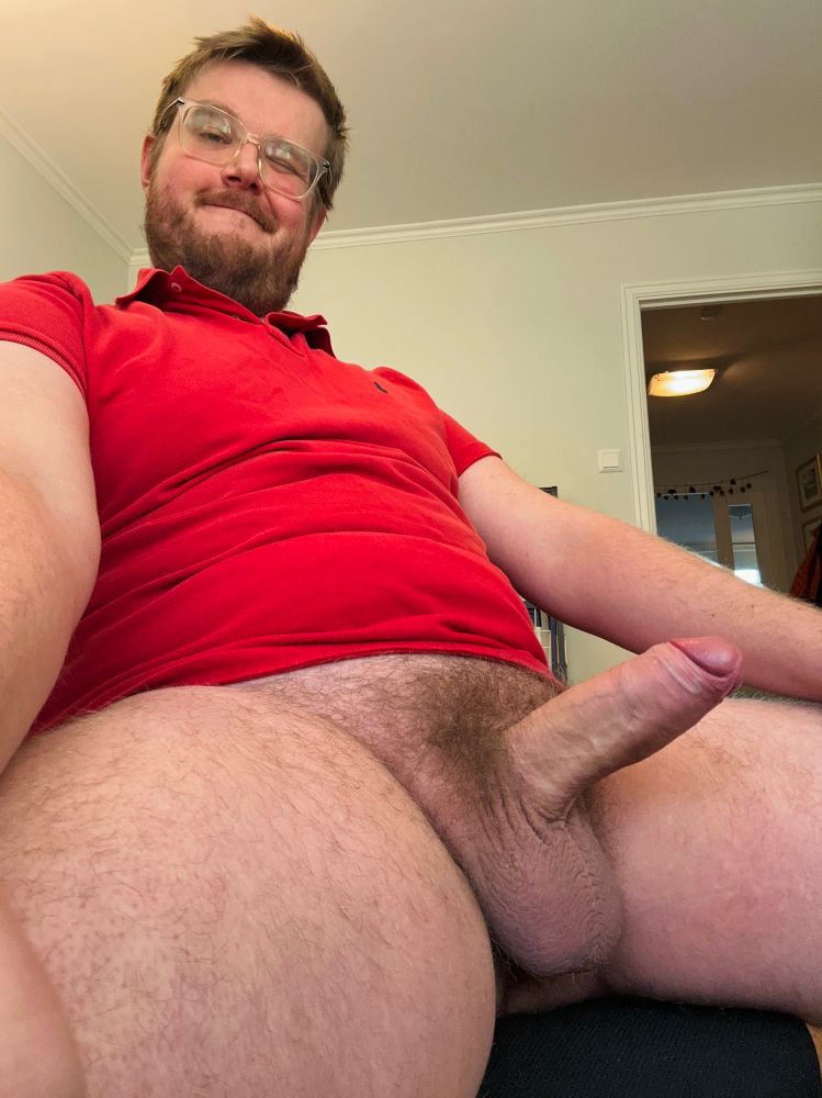Naked man in red shirt showing off hard uncut cock