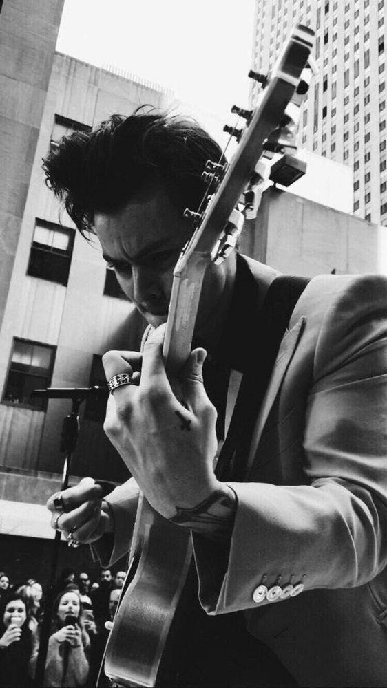 Harry Styles playing guitar in New York City - black and white picture 