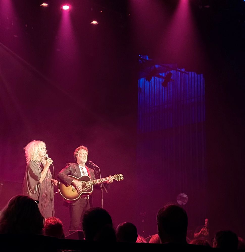 rufus wainwright playing guitar and singing with a woman