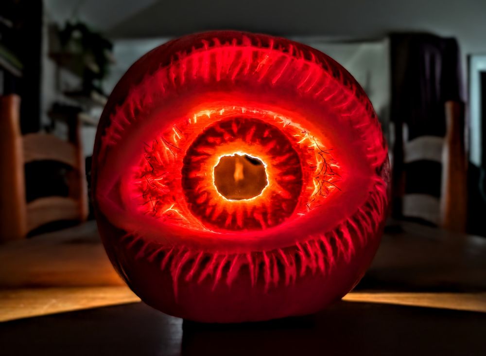 Lit up pumpkin eyeball with stitches - straight on view.