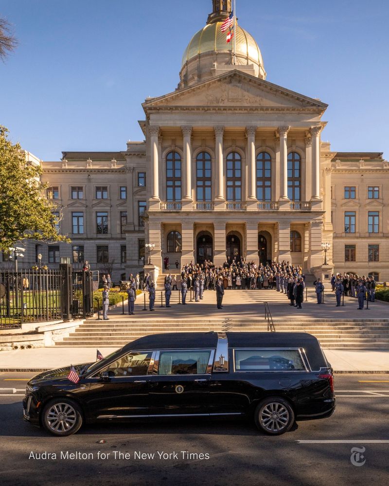 A hearse parked in front of the Georgia State Capitol, where a crowd is assembled. Photo by Audra Melton for The New York Times