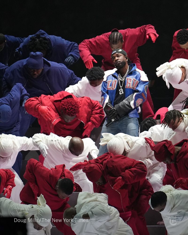 Kendrick Lamar stands surrounded by dancers wearing red, white and blue. Photo credit: Doug Mills/The New York Times.