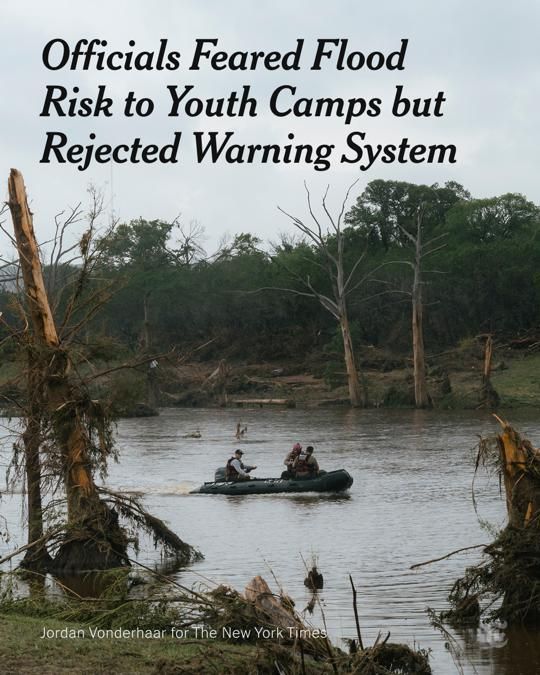 Rescuers sit in a small boat on a river surrounded by destroyed trees.