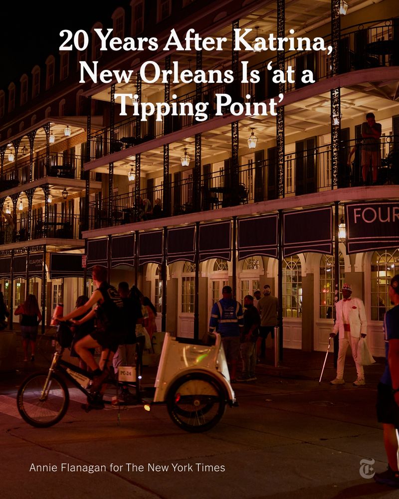 A lively street scene in New Orleans at night show a multi-story building with classic wrought-iron balconies is brightly lit, and people are visible on the balconies and the street below. A headline reads: “20 Years After Katrina, New Orleans Is 'at a Tipping Point.'” Photo credit: Annie Flanagan for The New York Times.