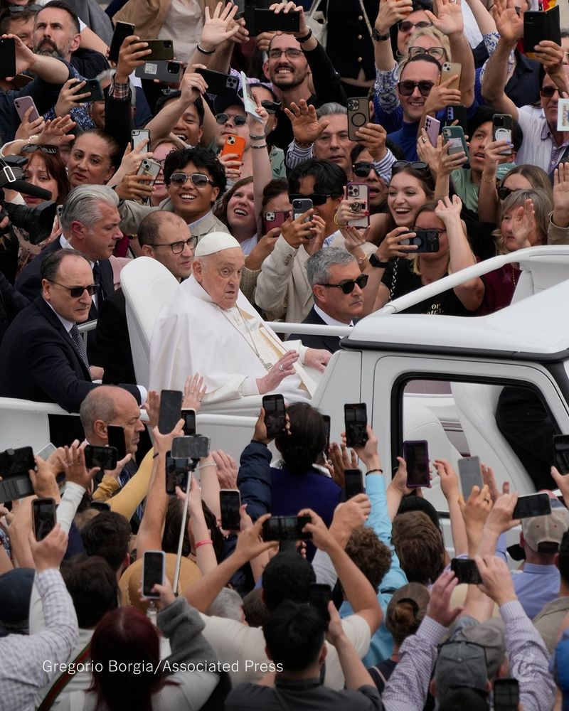 Pope Francis touring St. Peter's Square in his popemobile on Easter Sunday as crowds of people hold their phones toward him. Photo by Gregorio Borgia/Associated Press