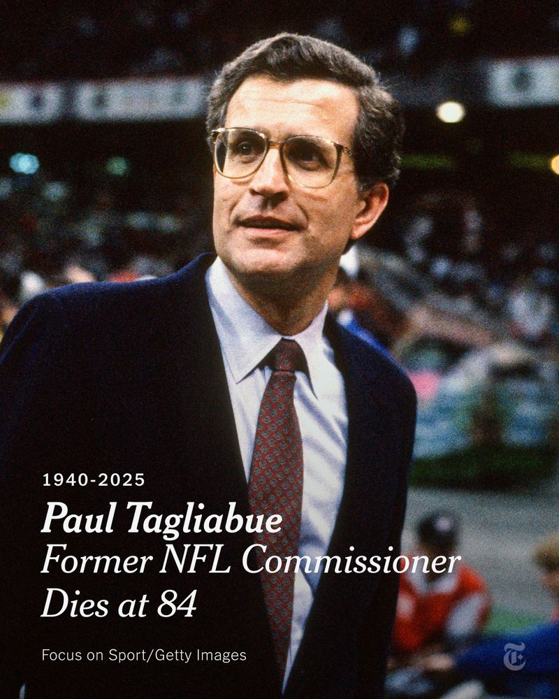 Paul Tagliabue in 1990, wearing glasses, a dark sports coat, a white shirt and tie. He is standing inside a stadium. A headline reads: "1940-2025: Paul Tagliabue, Former NFL Commissioner, Dies at 84." Photo by Focus on Sport/Getty Images