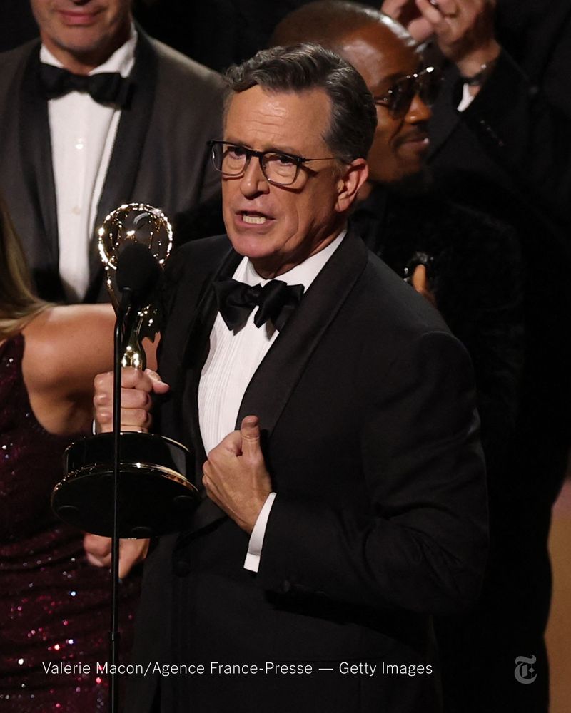 Stephen Colbert holds an Emmy award and speaks into a microphone. Photo credit: Valerie Macon/Agence France-Presse - Getty Images.