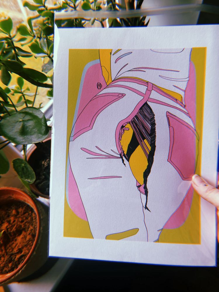 a hand holding art depicting someone venturing over in ripped jeans, the style is abstract in yellows pinks and greens. there are plants next to it 