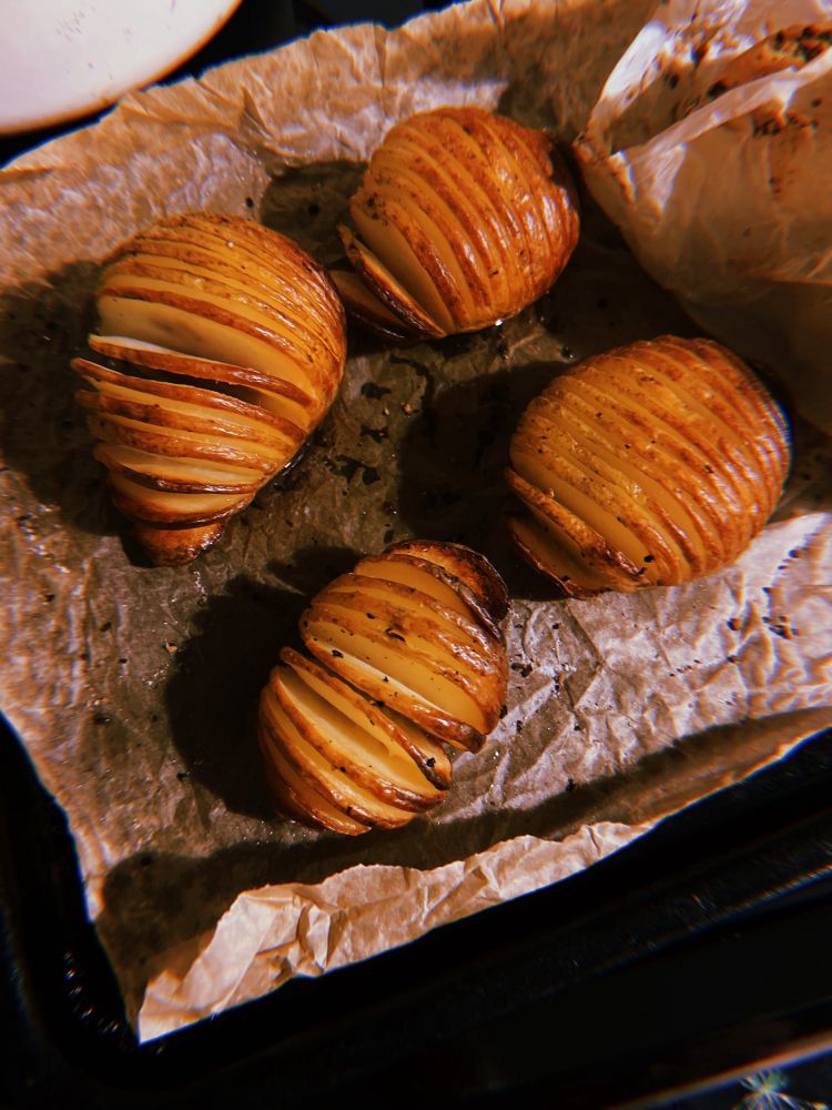 four hasselback potatoes on a tray 