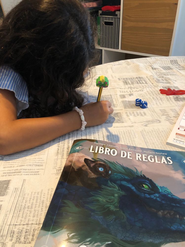 Mi hija anotando a lápiz en su hoja de personaje de Gatitos Mágicos al Rescate. 
