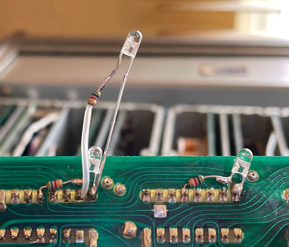 LEDs and resistors soldered to the back of a PCB to fault find 