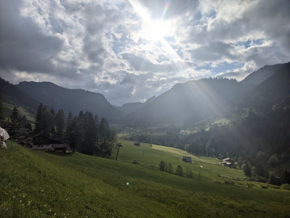 View of mountains with sun shining through clouds 