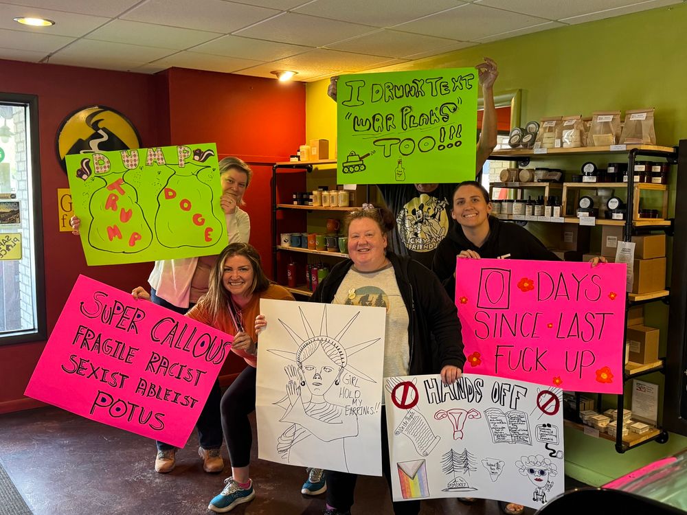 Group photo of multiple posterboard protest signs. Green sign with I drunk texted war plans too, pink sign with 0 days since last fuck up, green sign with Dump Trump and Doge, pink sign with Super Callous Fragile Racist Sexist Ableist POTUS, Sign with Statue of Liberty, and Sign with Hands off Constitution, uterus, books, stethoscope, pride flag, forest and national park, and granny with walker. 
