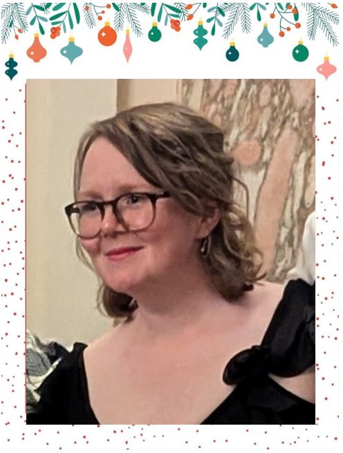 close up picture of a woman with glasses, looking to the side of the photograher. 