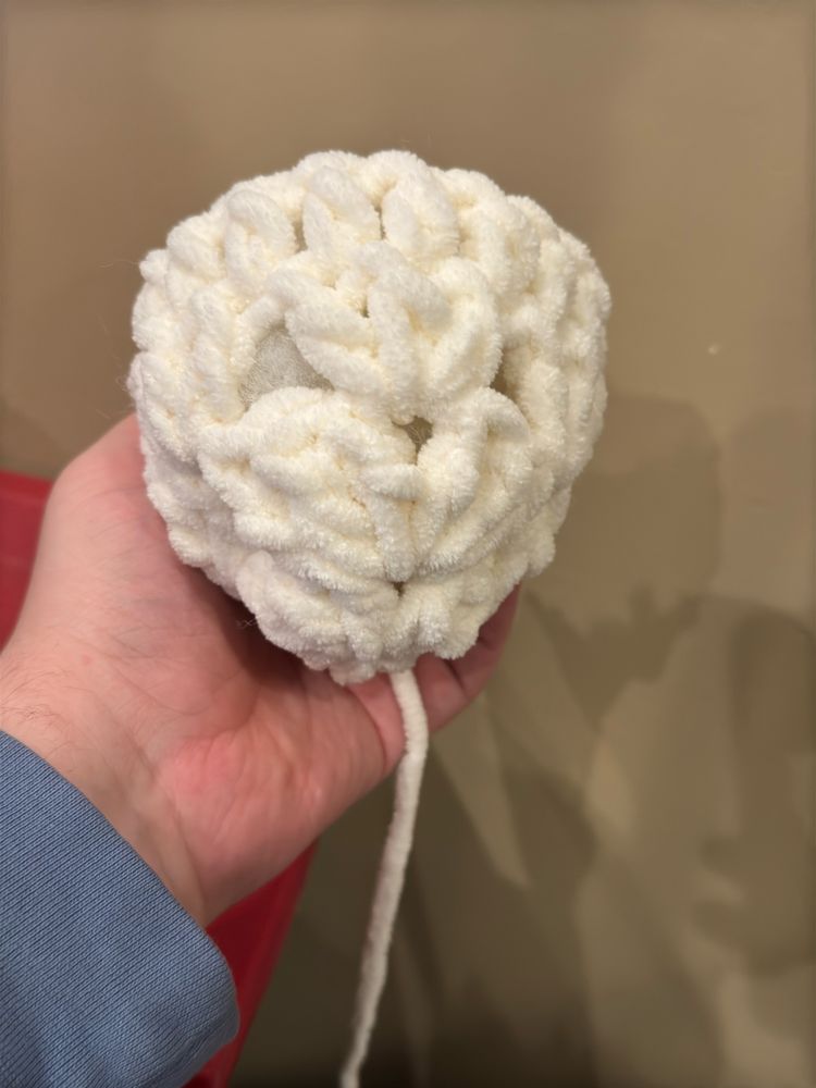 Crocheted ball full of stuffing not fully closed or attatched to hat