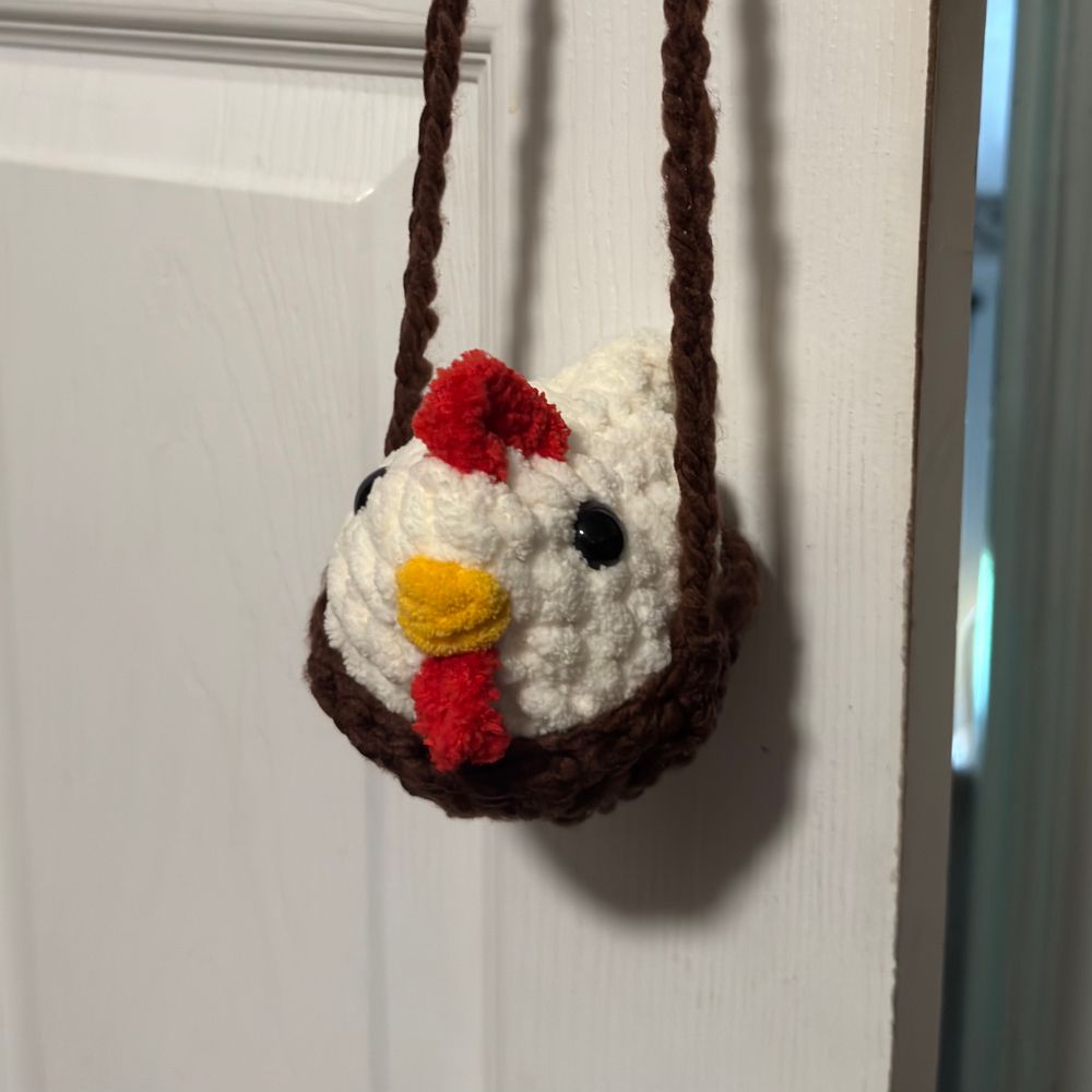 Crocheted chicken in a brown crocheted hanging nest hanging on from door knob