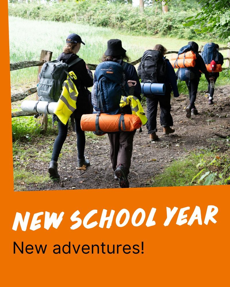 Group of hikers with backpacks walking through a green forest, with text overlay stating "New School Year New adventures!"