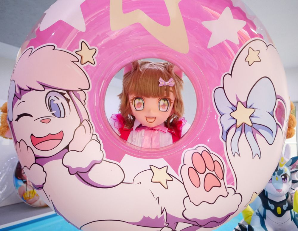 Holding a big pink swim ring while looking through the hole, wearing an anime cosplay.