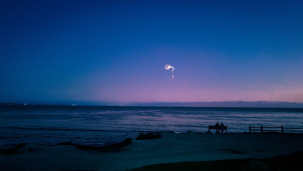 An exploding rocket at sunset over the Monterey Bay as seen from East Cliff Drive in Santa Cruz, CA.
