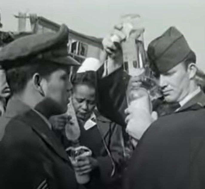 Abbie Sweetwine preparing a plasma infusion at the site of the crash. She is a black woman, surrounded by white men.

