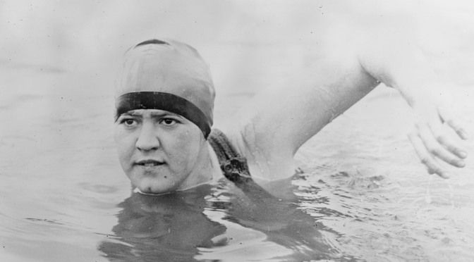 Gertrude Ederle swimming what looks like the front crawl. She is a white woman with her hair in a bathing cap.