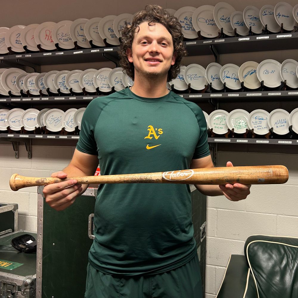Nick Kurtz stands with the Tater-brand bat he swung on July 25 as he went 6-for-6 with four home runs and 19 total bases, each tied for the most in a single game since at least 1900. (Photo courtesy: Athletics)
