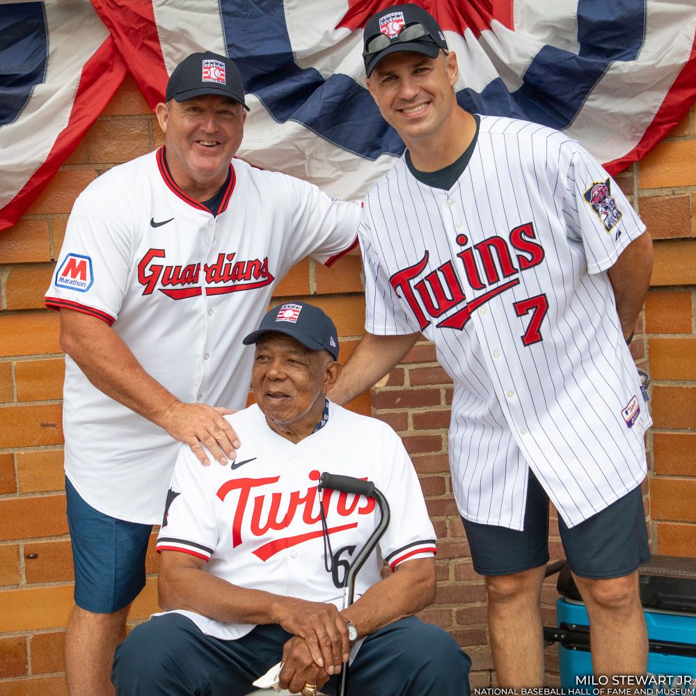 From left, Jim Thome, Tony Oliva and Joe Mauer pose in Guardians and Twins jerseys at Doubleday Field during Turn Two. (Milo Stewart Jr./National Baseball Hall of Fame and Museum)