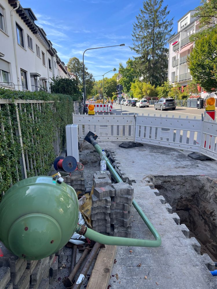 Im Vordergrund liegt eine alte schöne Gasleuchte und im Hintergrund sieht man schon die neu aufgestellten, unschönen, sehr hohen, moderne LED Strassenlampen.