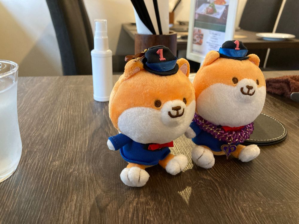 テーブルに置かれたポリまるキーチェーン二体の写真。