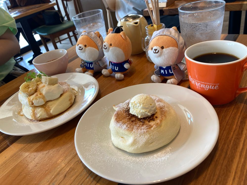 テーブルの上のパンケーキの写真。お皿の奥にはカップと3匹のポリまるぬいぐるみが座っている。