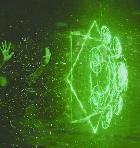 An unseen person casting a complex spell made of green energy.