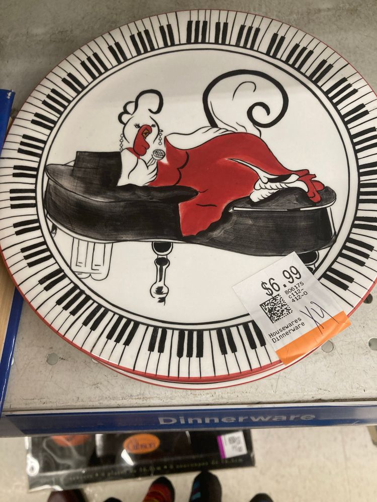 A plate with a drawing of a chicken dressed as a sultry lounge singer, reclining on a piano.