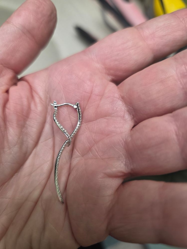 Diamond earrings ribbon shaped in hand 