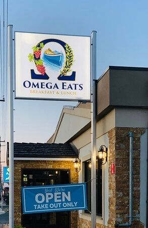 A restaurant sign that reads, "Omega Eats."