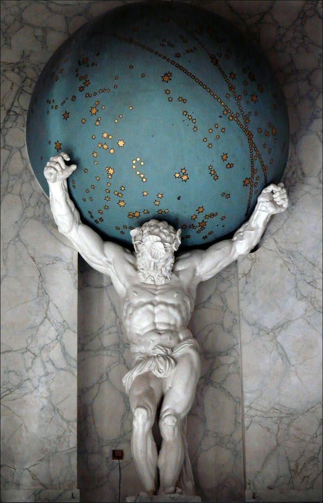 Statue of Atlas holding up the sky, from the Royal Palace in Amsterdam. Atlas is carved from white marble, heavily muscled and wearing only a loincloth. The sky is depicted as a turquoise globe with gold constellations picked out on its surface.