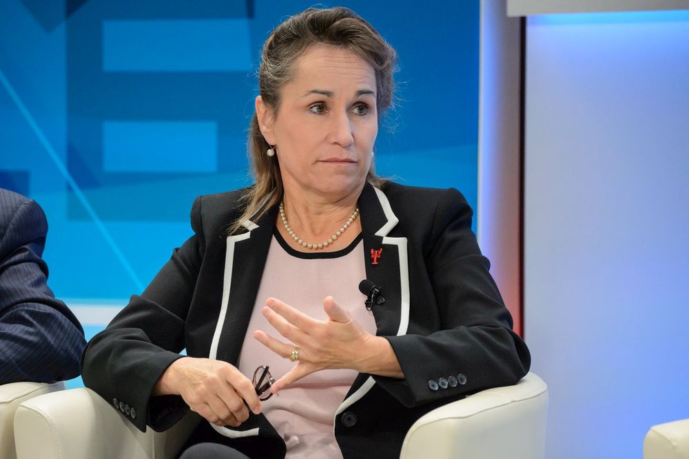 A 20 November 2016 photo of Greta Bossenmaier, who was the Chief of Canada's Communications Security Establishment at the time. Bossenmaier is wearing a black jacket with white trim around the lapels, a style identical to that worn by inmates of the Village in the iconic TV series The Prisoner.