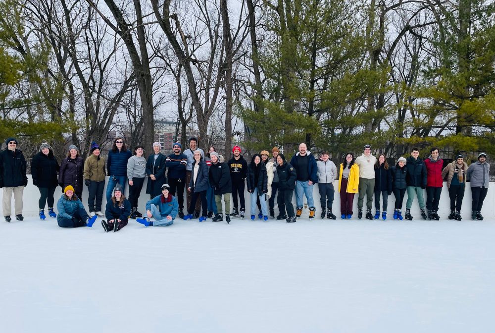 Group photo on the ice rink with trees in the background 