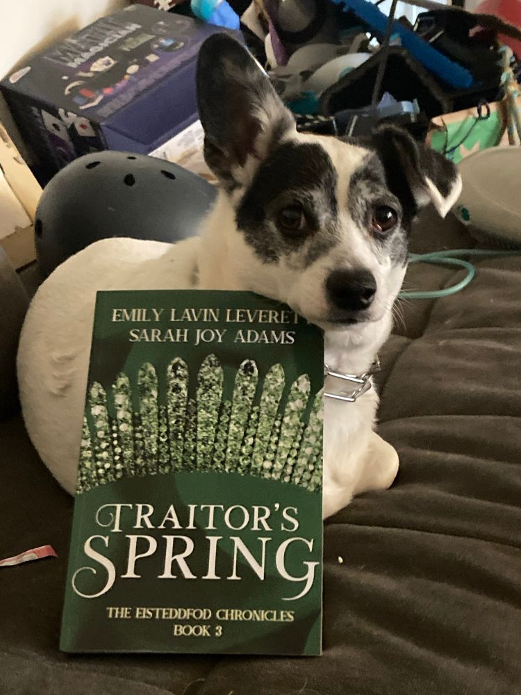 A cute dog invites you to read Traitor's Spring by Emily Lavin Leverett and Sarah Joy Adams.