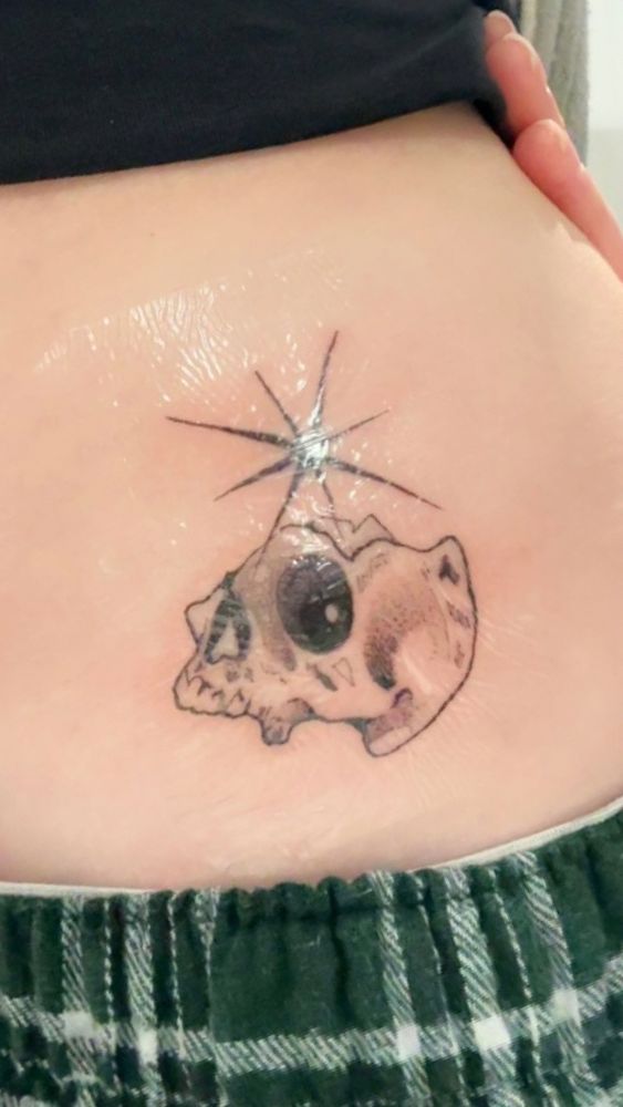 Tattoo of a broken skull and a large star above it. 