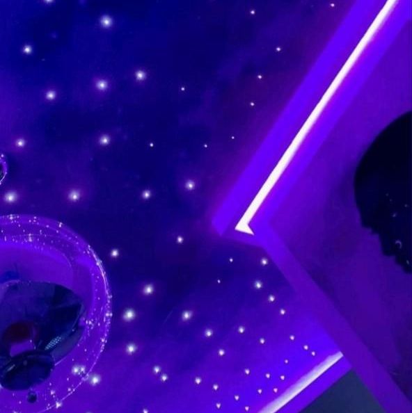 The purple and blue lit ceiling of Jihoon's studio. Lights scattered across the ceiling give the impression of stars