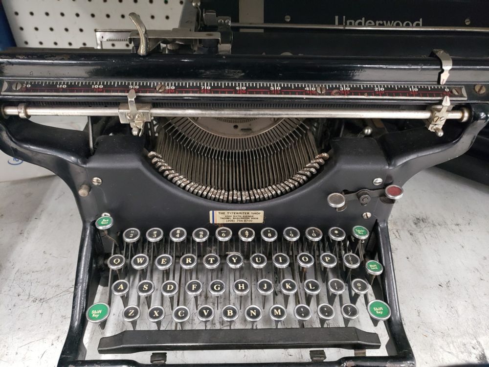 A photograph of an Underwood Model 3 Manual Typewriter sitting on a store shelf.
