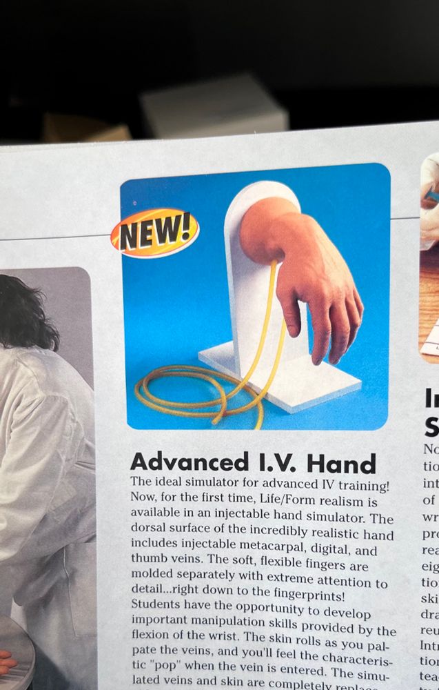 Medical model textbook shows a model titled “Advanced I.V. Hand”, with a hand hanging downwards limply. 