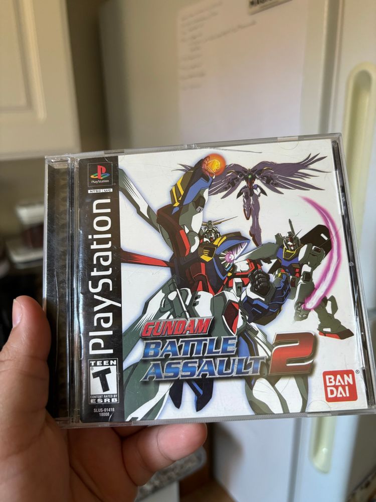 Ursa holds the case for the Playstation game “Gundam Battle Assault 2”.