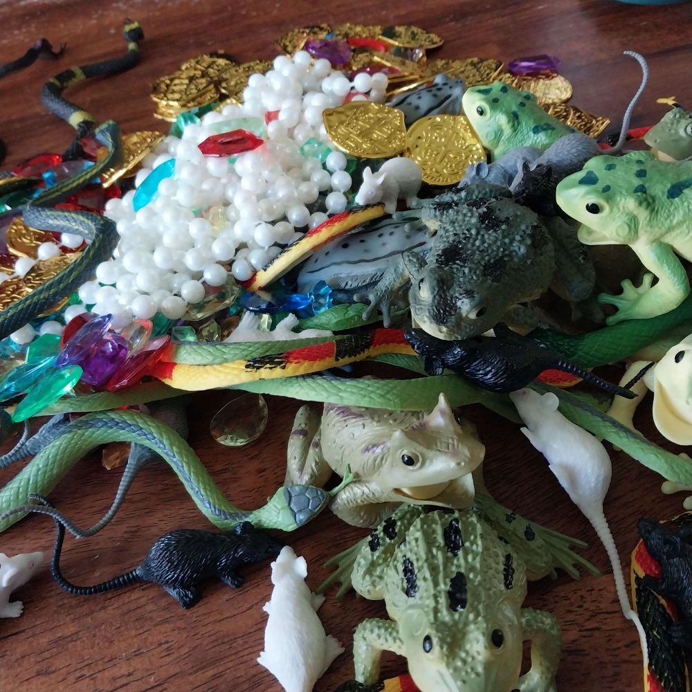 a pile of fake toads, snakes, rats, pearls, gems, and gold coins