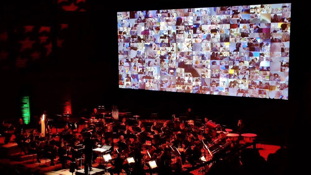 Das Symphonie-Orchester "Prague Royal Philharmonics" in der IsarPhilharmonie München, für die Aufführung des Films "Tatsächlich Liebe" auf der Großleinwand mit Live-Orchester. Schlussszene des Films mit einem Mosaik aus vielen Liebesmomenten am Flughafen. 
