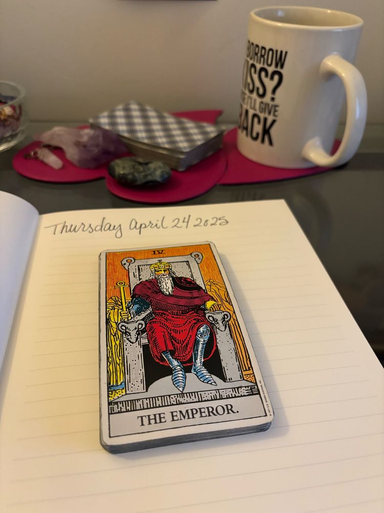 The Emperor card from the major arcana of the tarot on a lined page in an open journal 